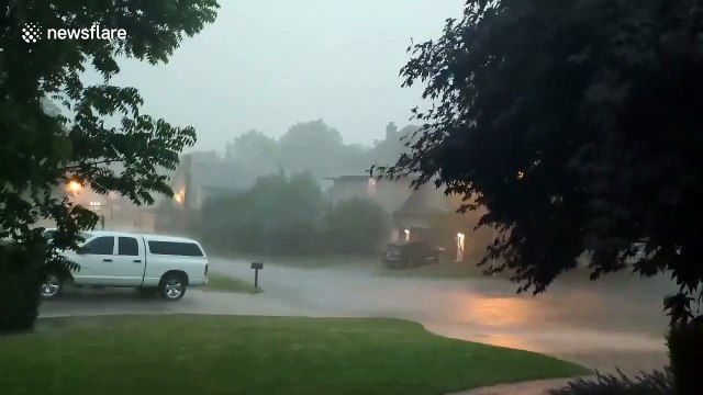 Ominious tornado sirens sound off as heavy rain falls and lightning flashes all around Tulsa, Oklahoma