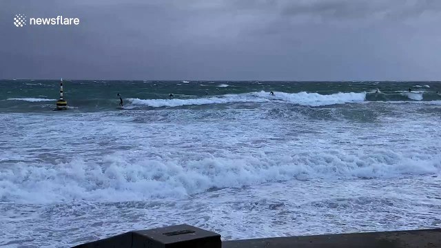 Surfers flock to the sea as several weather warnings issued bracing Australia for storms