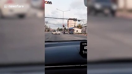 Food delivery rider stops traffic to help frail pensioner cross road in Thailand