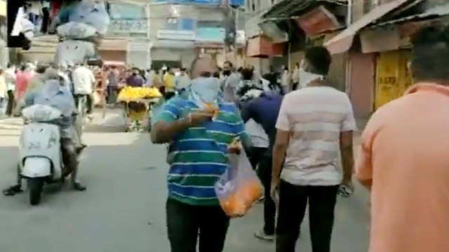 Delhi:Man showers flower petals on queue outside liquor shop