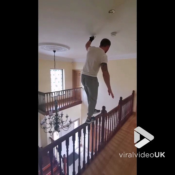 Sport extrême à la maison il marche en équilibre sur la rampe d'escalier