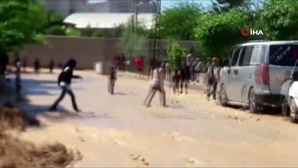 Çocukların patlayan borudan akan suda çamurla oyunu