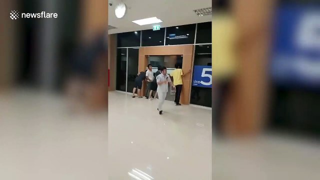 Hospital staff hold the doors shut as tropical storm batters building in Thailand