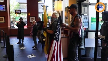 Un manifestant anti-confinement se balade avec un lance-roquettes