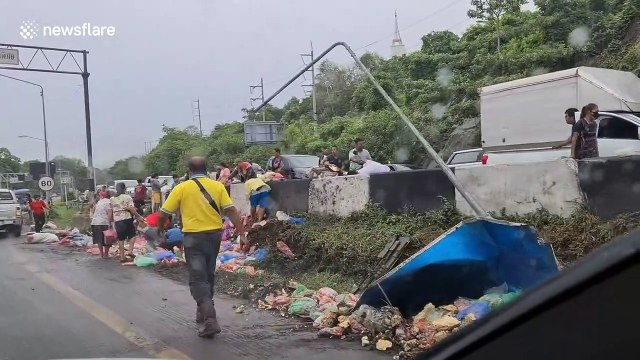 Hungry Thai locals scavenge two tons of sausages spilled from overturned truck
