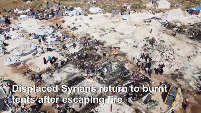 Displaced Syrians try to salvage belongings after fire rips through Idlib camp