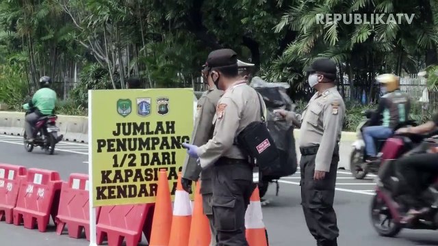 Petugas gabungan memasang plang pemberitahuan pemeriksaan penerapan Pembatasan Sosial Berskala Besar (PSBB) di Jalan Laks. Laut RE Martadinata, Purwakarta, Jawa Barat.
