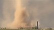 Tornado stirs up dust at an open field
