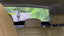 Biker Tries Doing Wheelie and Crashes Bike Into Moving car on Undivided Highway