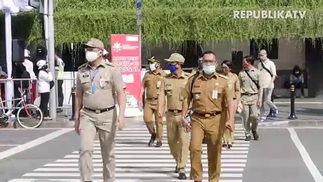 Penumpang menerapkan jarak sosial saat menaiki bus Transjakarta di Halte Harmoni, Jakarta.