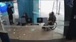 Deux hommes attendent qu'un homme en fauteuil roulant retire de l'argent pour le voler
