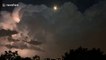 Intense lightning illuminates Toronto as the moon pokes through storm clouds