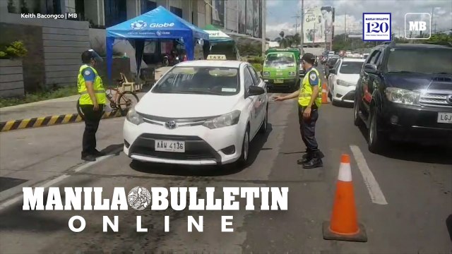 Police auxiliaries check food and medicine passes of commuters in Davao City