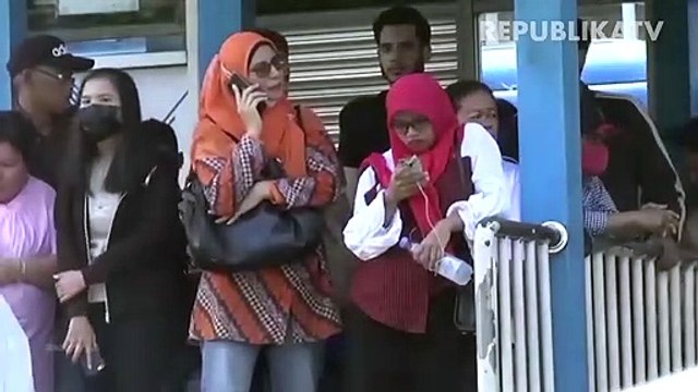 Penumpang menerapkan jarak sosial saat menaiki bus Transjakarta di Halte Harmoni, Jakarta.