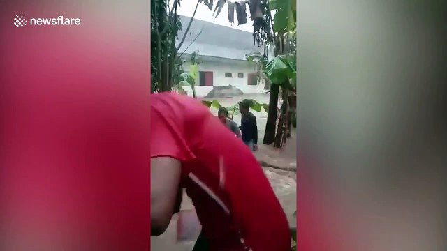 Family rescued from stranded car washed away by floods in Indonesia