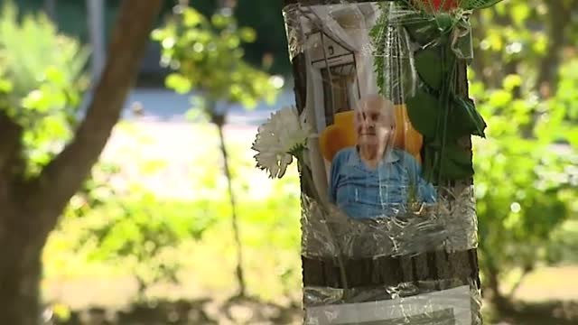 Familiares de fallecidos en residencias colocan sus fotos en árboles frente a los centros