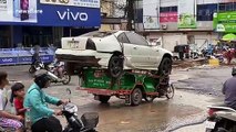 Overloaded motorcycle carries scrap car on the back in Cambodia