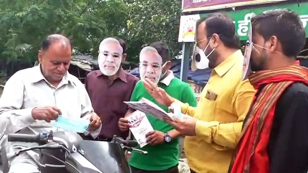 भाजपा नेता अभिषेक ने प्रधानमंत्री नरेंद्र मोदी का मुखौटा लगाकर बांटे पत्रक