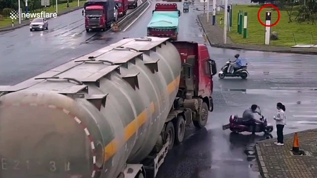 Chinese scooter rider narrowly avoids being run over by truck after falling in front of it