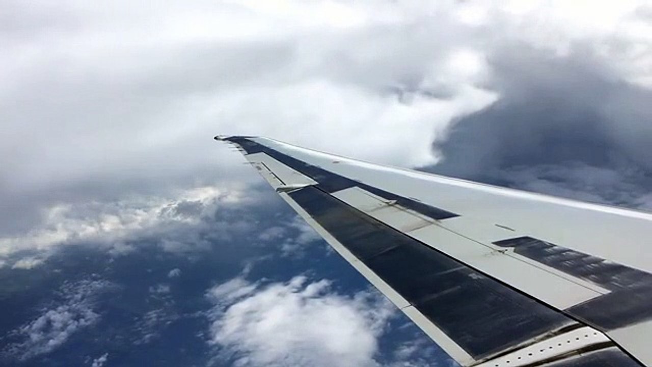 looking out airplane window during flight over clouds