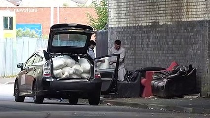 Bizarre moment UK men filmed removing stuffing from fly-tipped sofas