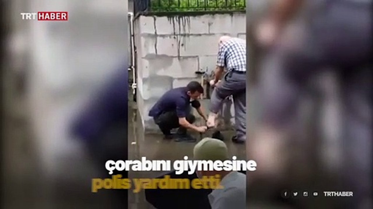 Rize'de bir polis, abdest alan yaşlı adamın çoraplarını giydirdi