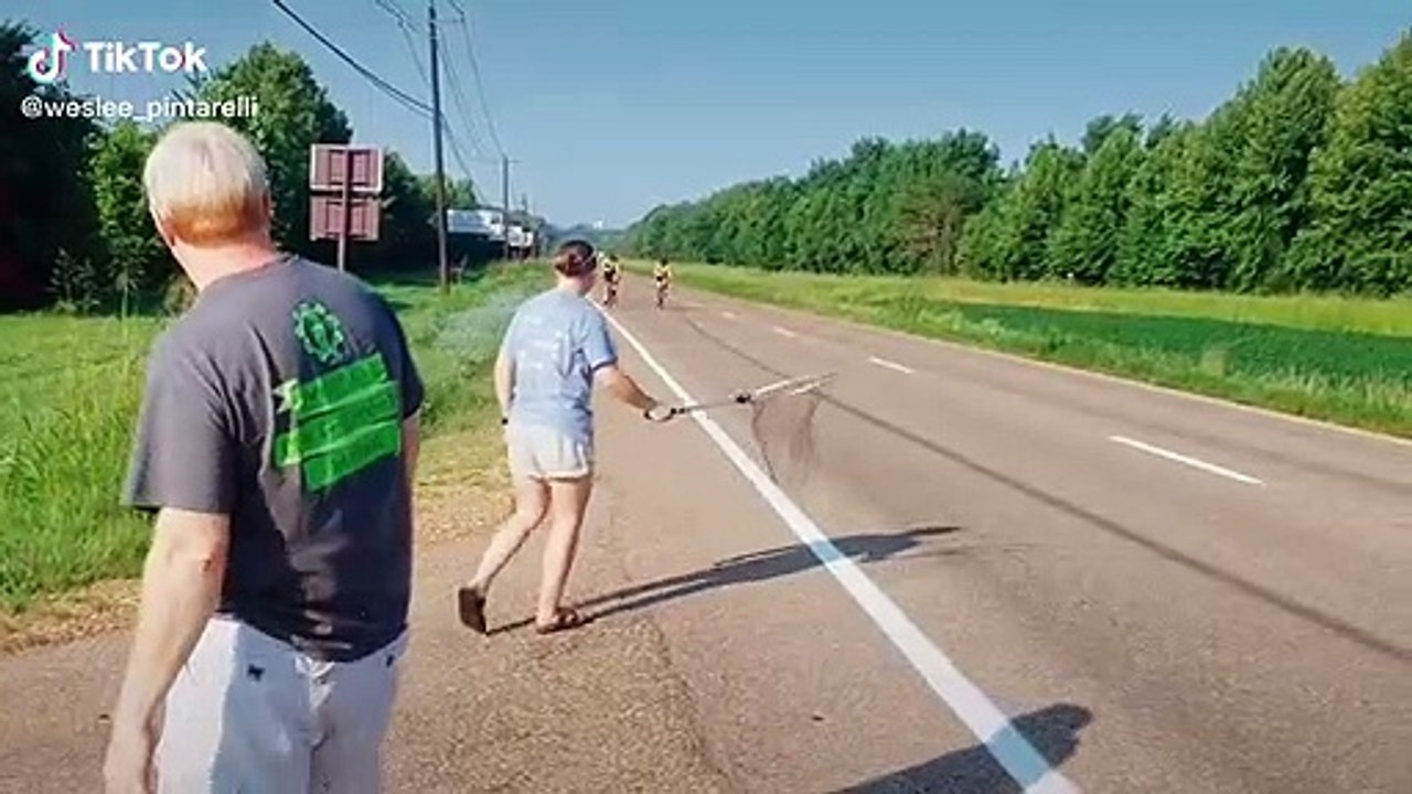 Elle récupère les bidons des cycliste à l'aide d'un filet