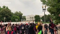 Black Lives Matter protesters wave to White House snipers