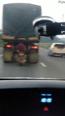 Motorcyclists Hiding From Rain Behind a Truck