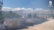 Bomberos intentan atajar incendio de pastos en el antiguo poblado de El Gallinero