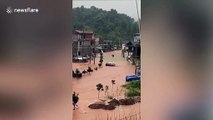 Chinese motorist climbs out of car window to escape as vehicle washed away by flash floods