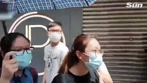 Hong Kong cop points gun at protesters while people scream in pepper spray and water cannon attacks