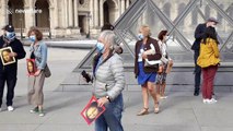 Tour guides hold Mona Lisa portraits as they protest during reopening of the Louvre Museum in Paris