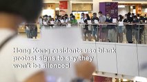 Hong Kongers hold blank sheets of paper to protest security law