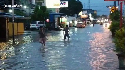 Groups of children swim in flooded road in Indonesia