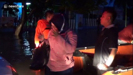 Indonesian pedestrians transported by rubber boats after persistent rain leaves Padang flooded