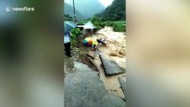 Chinese rescuers desperately hold elderly man caught up in torrential floods