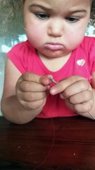 Cute Kid Concentrates to Thread a Needle