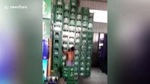 Chinese worker lifts stack of nine boxes of beer in one go