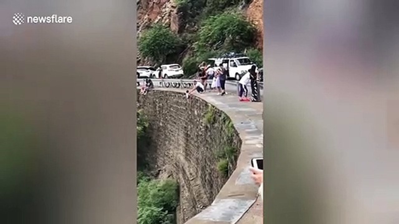 Un papa suspend son fils au-dessus du vide pour une photo