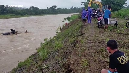 Villagers try to save truck washed away by river in the Philippines