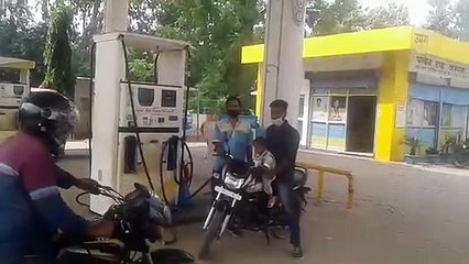 पेट्रोल पंप पर सामाजिक दूरी का पालन करते हुए पेट्रोल वितरण