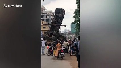 Truck-mounted crane topples over on busy road in Cambodia