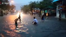 Kids play rainy street soccer during knee-deep flooding in Indonesia