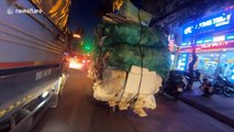 Overloaded motorcycle carries countless garbage bags on streets of Vietnam