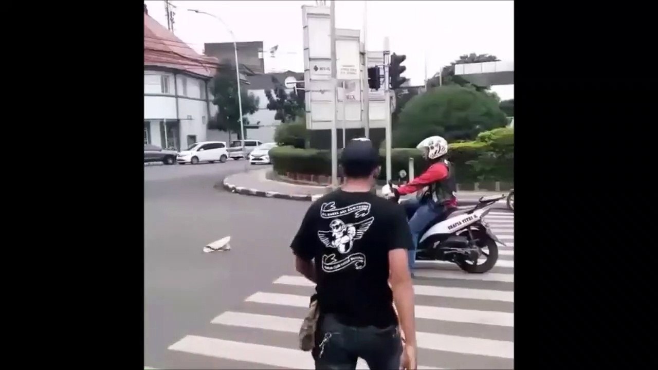 Ce piéton punit un scooter arrêté sur un passage piéton