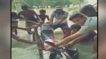 Man ignores fast water flow, gets stuck into flood with bike