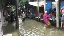 Residents wade through water as streets flood