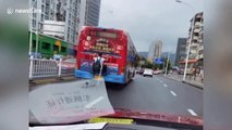 Chinese man spotted clinging onto back of bus moving along road