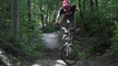 Guy Riding Bike on Forest Trail Jumps Over Obstacle and Falls Hard on Ground